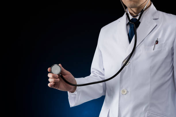 istock Doctor in white coat, black background. 1180864303