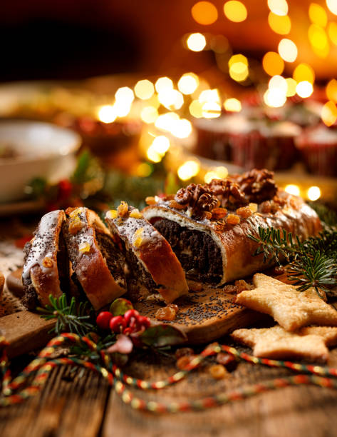 istock Christmas poppy seed cake, sliced poppy seed cake covered with icing and decorated with raisins and walnuts on the holiday table. 1180872644