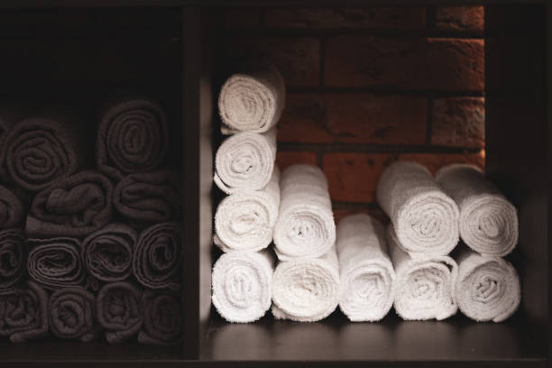 istock White and black towels folded into a roll. Brickwork in the background. Presentation of textiles. Rational use of space. 1180883821