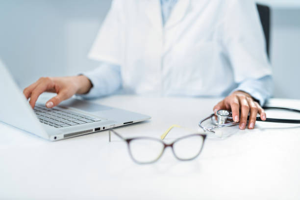 istock Young female doctor holding stethoscope on her desk while working close up. 1180884920