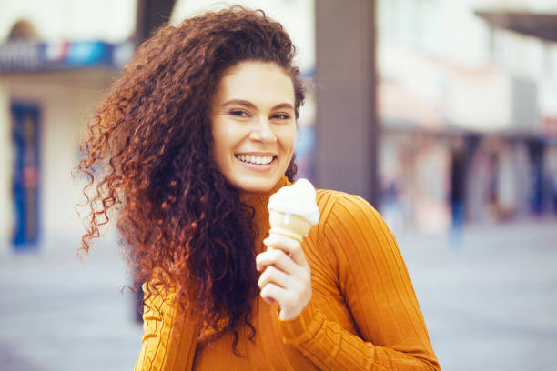 istock Beautiful woman eating ice-cream 1180885218