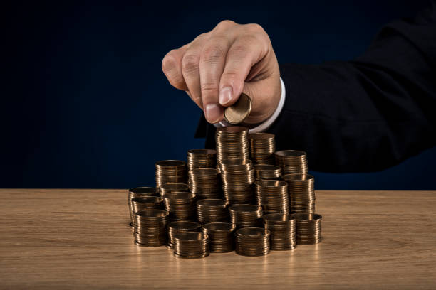 istock Stacked coins and male hand 1180888804