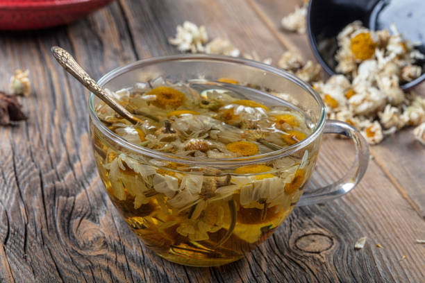 istock Cup of medicinal chamomile tea. Chamomile tea on the wooden table. 1180888839