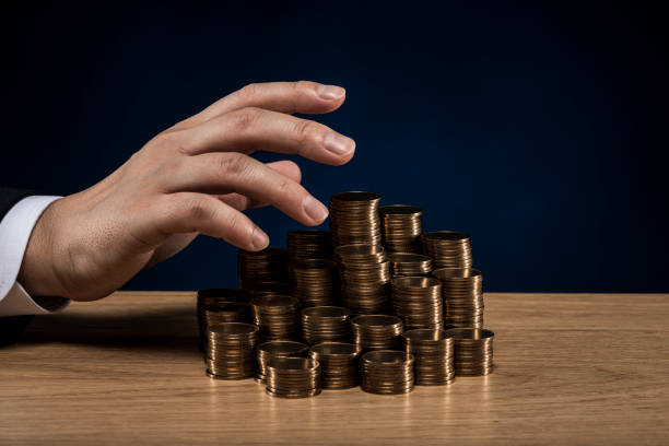 istock Stacked coins and male hand 1180888858