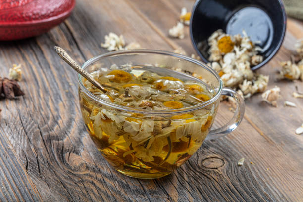 istock Cup of medicinal chamomile tea. Chamomile tea on the wooden table. 1180889211