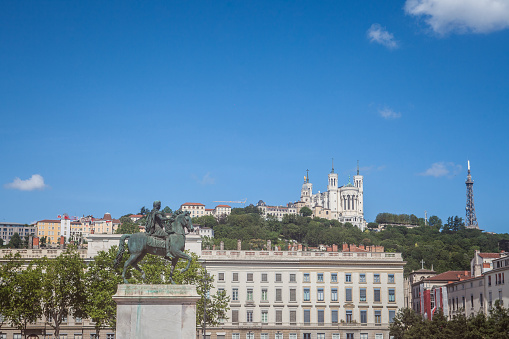 picture of Louis XIV statue with the Fourviere Basilica in background in Lyon. Inaugurated in the 19th century, this statue is the main landmark of the Place Bellecour square. La Place Bellecour is a large square in the centre of Lyon, France, to the north of the Ainay district