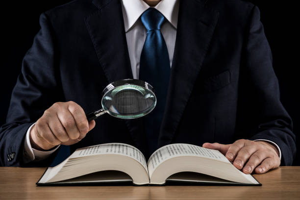 istock Businessman with open book on wooden desk 1180890188