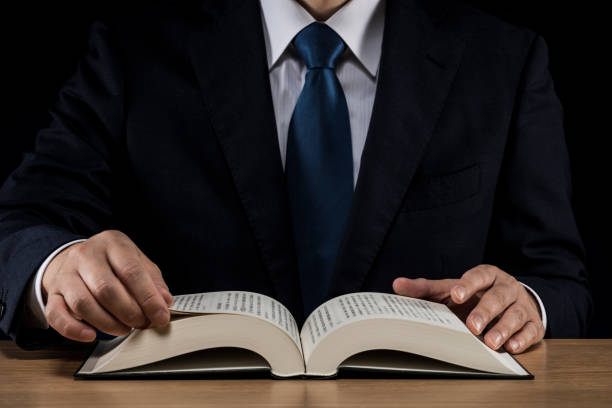 istock Businessman with open book on wooden desk 1180890740