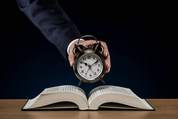 istock Businessman with open book and alarm clock 1180890831