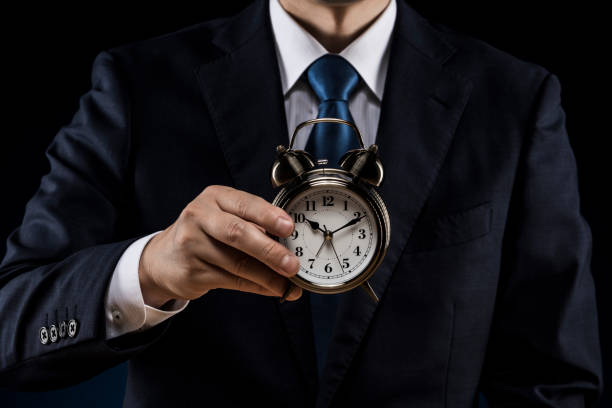 istock Businessman with alarm clock in hand 1180890855