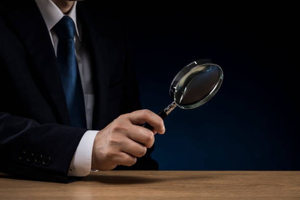 istock Businessman's hand holding a loupe 1180891018