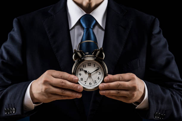 istock Businessman with alarm clock in hand 1180891029
