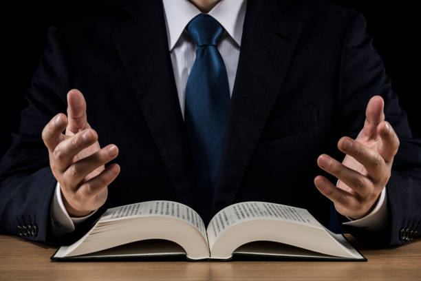 istock Businessman with open book on wooden desk 1180891038