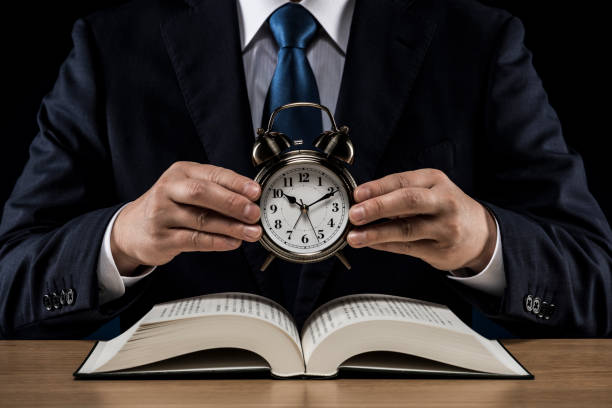 istock Businessman with open book and alarm clock 1180891051