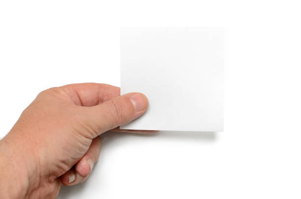 istock Man holds a white sheet of paper on a white background 1180892624