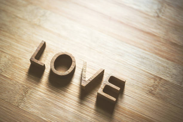 love wooden letters on rustic wood board background.