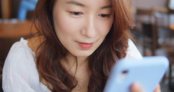istock Woman Using Smart Phone At Coffee Shop 1180894525