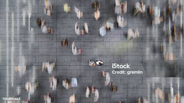 Businessman Standing In The Fast Moving Crowds Of Commuters Stock Photo - Download Image Now