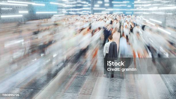 Businessman Standing In The Fast Moving Crowds Of Commuters Stock Photo - Download Image Now