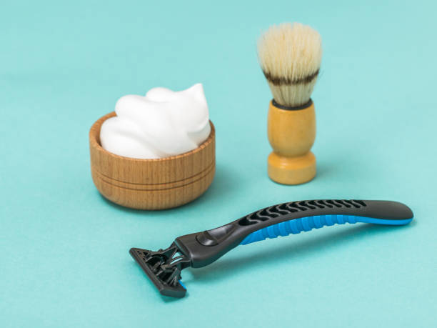 istock Shaving machine with shaving foam and brush on a blue background. 1180898467