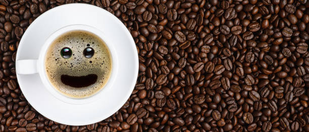 istock panoramic coffee background of a cup of black coffee with smiling face coffee bubble on background of roasted arabica coffee beans 1180898979