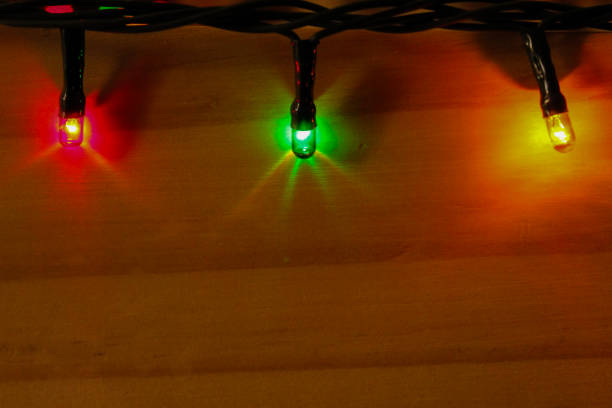 istock Three christmas led lights on a wood board 1180900467