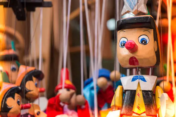 Wooden pinocchio dolls with long nose. Conceptual fairy tale character.