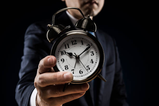 istock Businessman with alarm clock in hand 1180905498