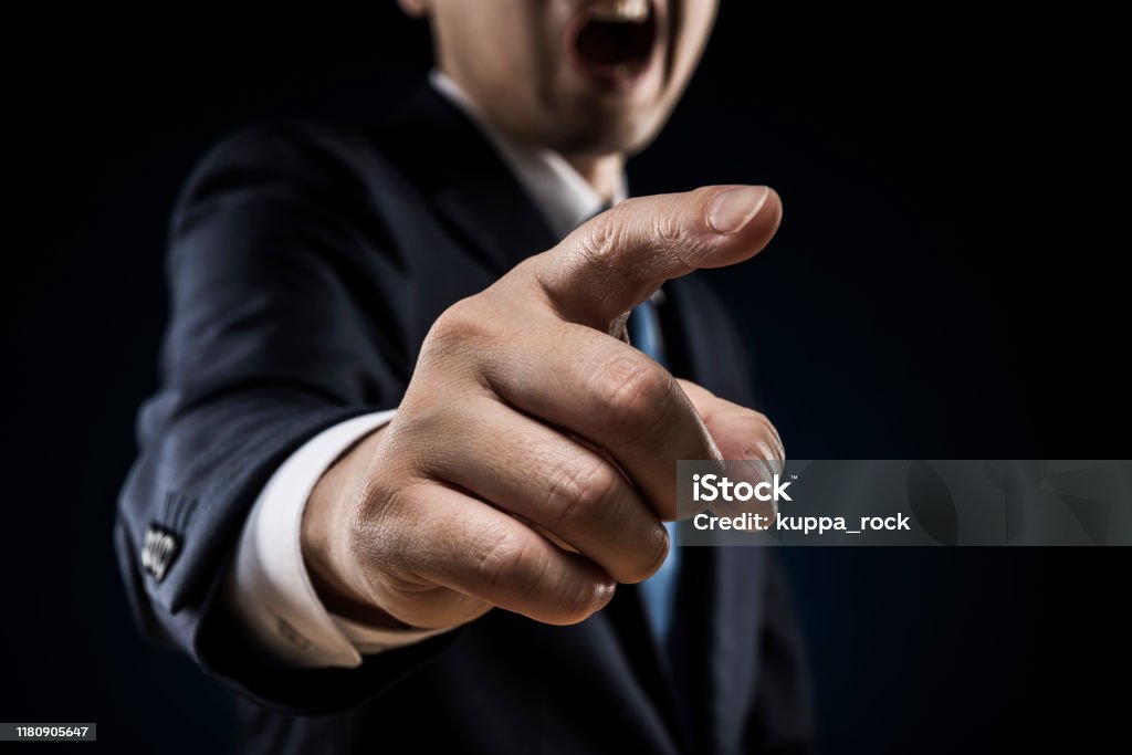 Businessman sticks out a finger and reproves it. Anger Stock Photo