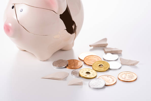 istock Cracked piggy and coins on white background 1180907477