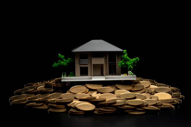istock Pile of coins and house model 1180911428