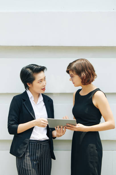 istock Businesswomen discussing report 1180912052
