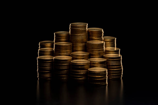 Pile of coins stacked on black background