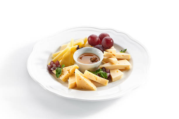 istock Cheese Platter with Honey, Nuts and Grapes on White Restaurant Plate 1180912382