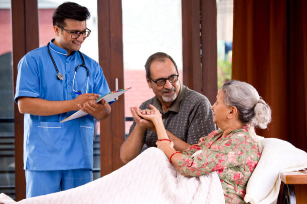 Male nurse making a note of senior patient at home Male nurse making a note of senior patient at home india hospital stock pictures, royalty-free photos & images