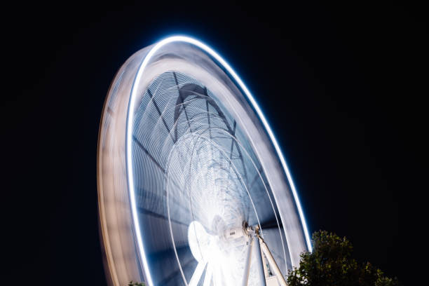 istock Ferris Wheel Spinning Long Exposure Neons Structure against Black Night 1180917403