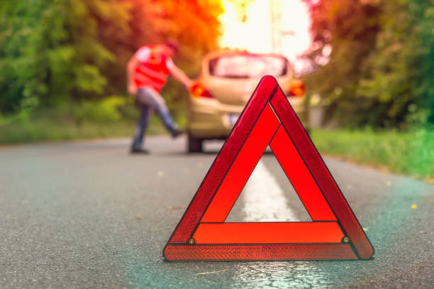 istock Angry driver kicking the tires on broken car 1180918376