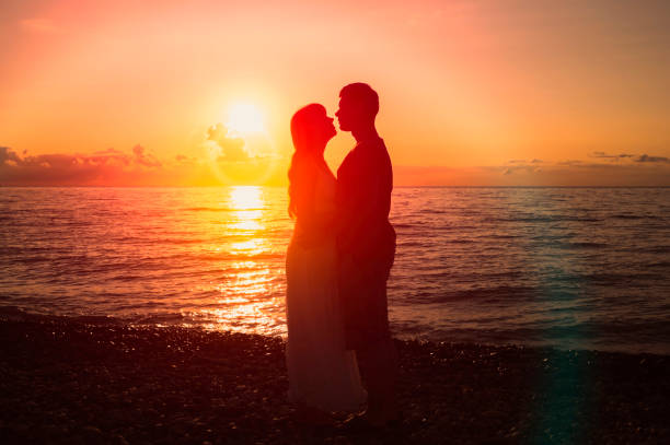istock Two young lovers standing on a beach and looking to each other 1180918427