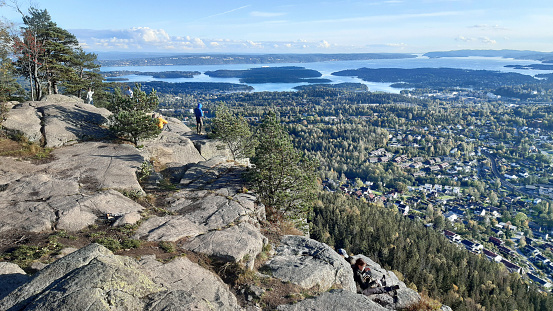 Oslo, Norway – September 29, 2019: People enjoy panoramic view to Oslo Fjord from Kolsåstoppen mountain in early autumn. Kolsåstoppen is a popular hiking area well-known for its spectacular panoramic views of Oslo, Bærum, and the Oslo Fjord.
