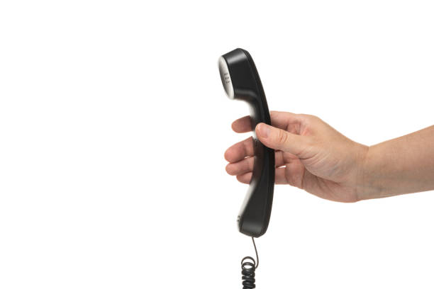 istock Male hand holding a handset on white background 1180922348