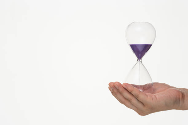 istock Male hand with hourglass on white background. 1180922572