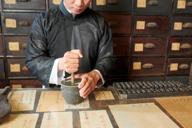istock Drugstore worker grinding up ingredients in mortar 1180924050