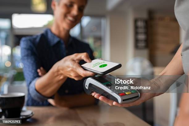 Woman Paying Using Nfc Technology Stock Photo - Download Image Now - Paying, Telephone, Mobile Payment