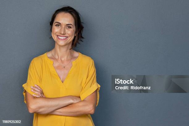 Happy Mature Woman Smiling On Grey Wall Stock Photo - Download Image Now - Women, One Woman Only, Portrait