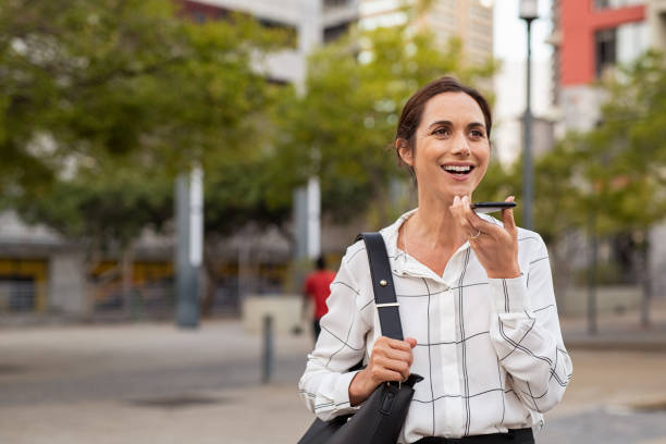 istock Business woman using speaker phone outdoor 1180925359