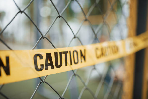 Do not enter. Yellow caution tape on the metal fence at daytime. Crime scene Do not enter. Yellow caution tape on the metal fence at daytime. Crime scene. barricade photos stock pictures, royalty-free photos & images