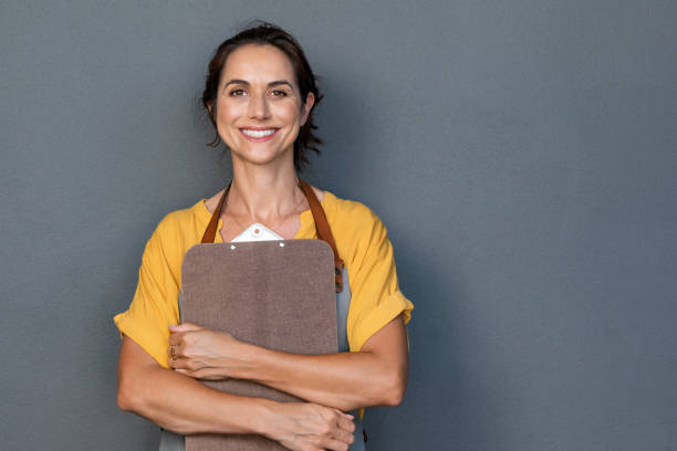 istock Woman entrepreneur in apron looking at camera 1180926156