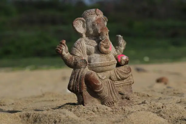 Ganapathi or vinayagar or ganesh handmade small statue in the sea after it vinayagar chaturthi festival. sea sands are filled in the statue