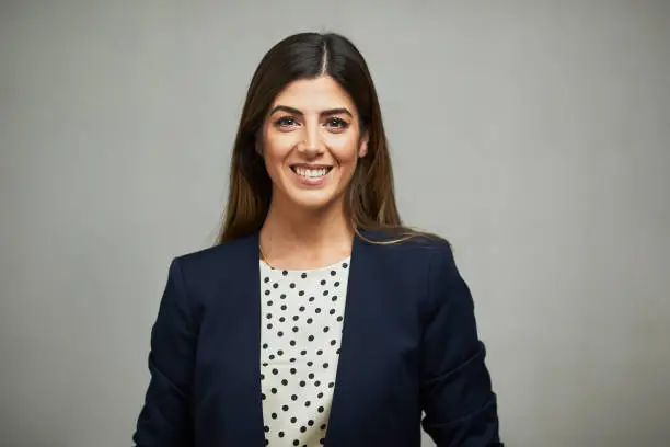 Photo of Front view of a woman wearing a suit and smiling.