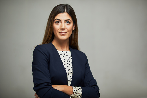 Studio waist up portrait of a beautiful businesswoman with crossed arms.